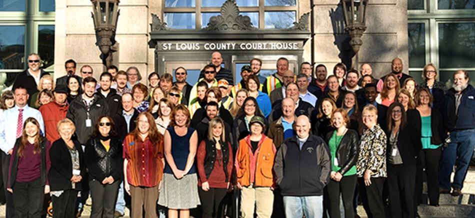 Large group of staff standing on the steps in front of the St. Louis County Courthouse 